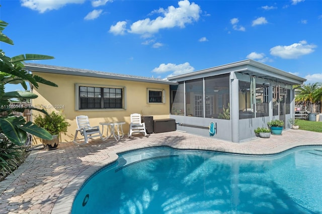 rear view of property featuring a sunroom and a patio