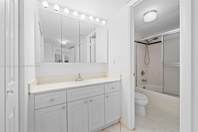 full bathroom featuring tile patterned flooring, vanity, combined bath / shower with glass door, and toilet