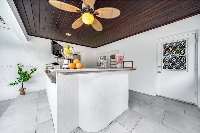 interior space with kitchen peninsula, light tile patterned flooring, and wood ceiling