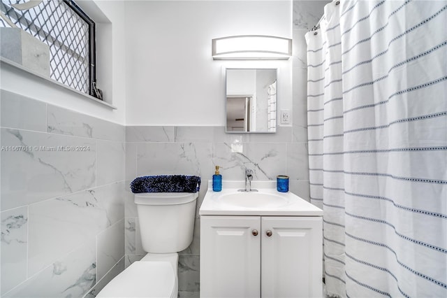 bathroom featuring vanity, toilet, tile walls, and curtained shower