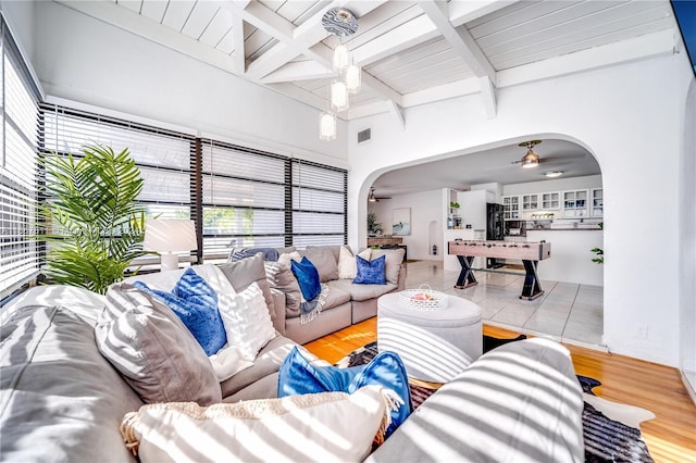 living room featuring beam ceiling, ceiling fan, and light hardwood / wood-style flooring