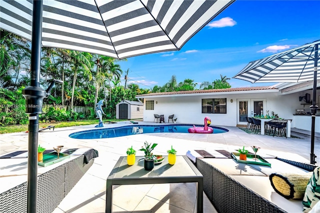 view of swimming pool with a storage unit, a patio, and french doors