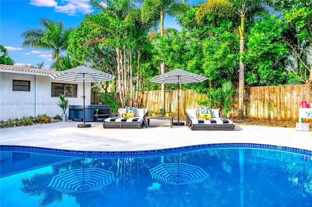 view of pool with outdoor lounge area, a patio area, and a hot tub