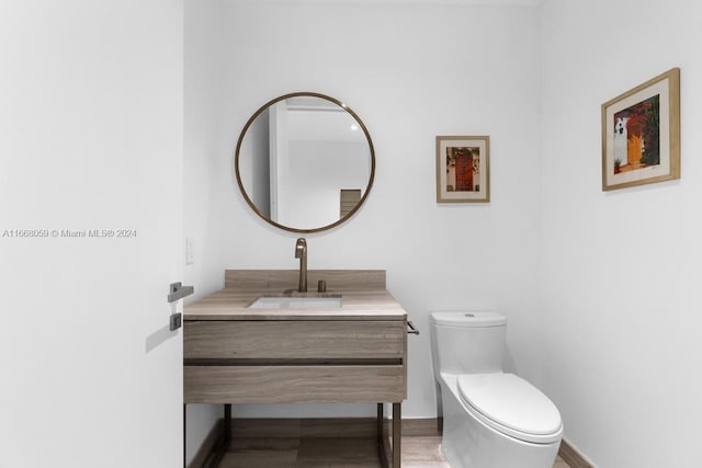 bathroom featuring vanity, hardwood / wood-style floors, and toilet