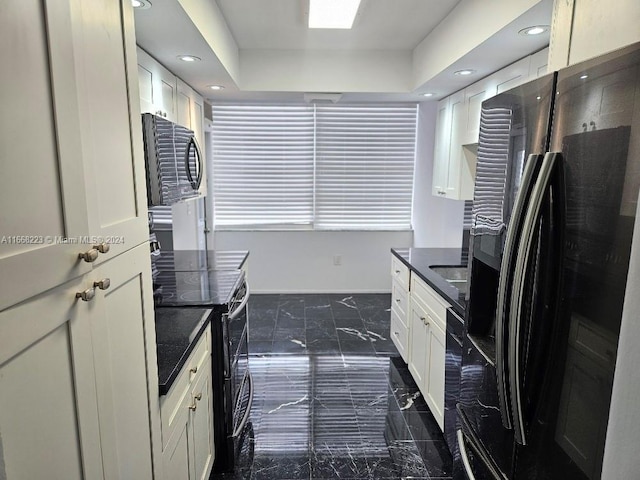 kitchen featuring fridge with ice dispenser, black range with electric cooktop, and white cabinets