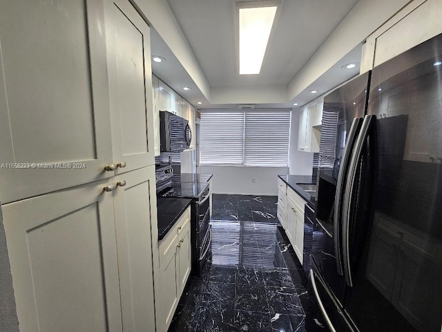 kitchen with black appliances and white cabinetry