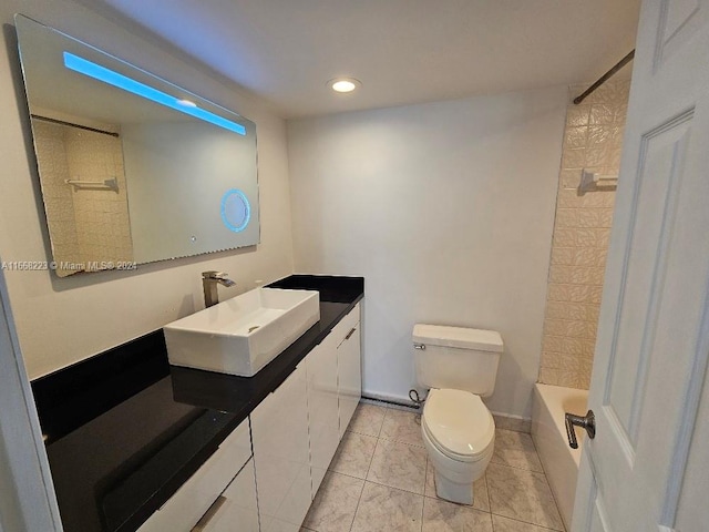 full bathroom featuring tiled shower / bath, vanity, tile patterned flooring, and toilet