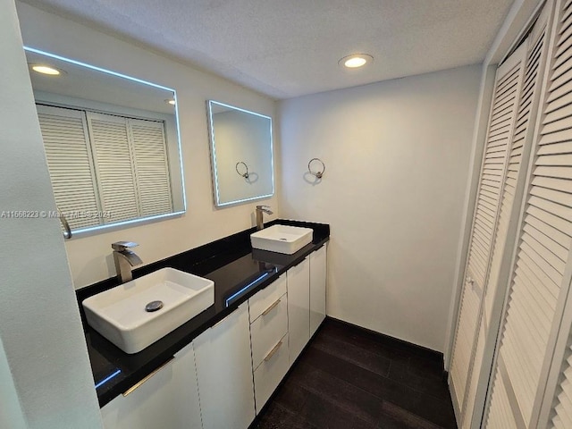 bathroom with wood-type flooring, a textured ceiling, and vanity