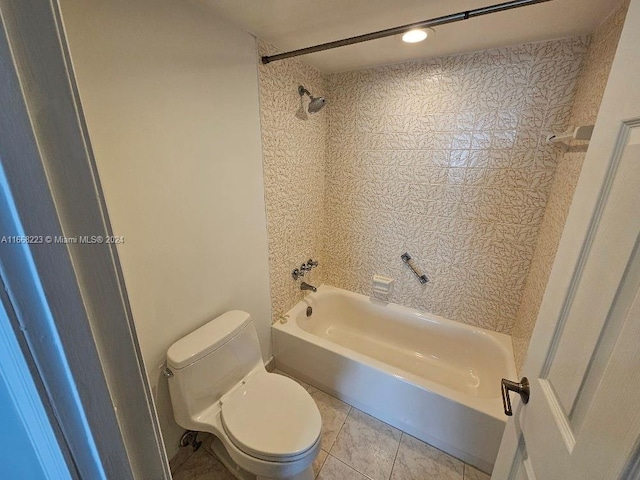 bathroom featuring tiled shower / bath, toilet, and tile patterned floors