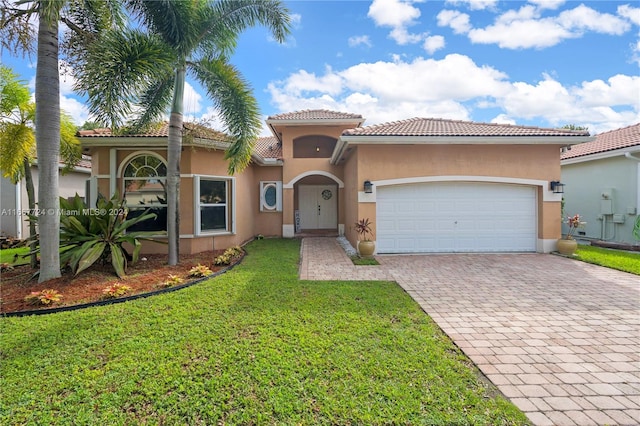 mediterranean / spanish house featuring a garage and a front yard