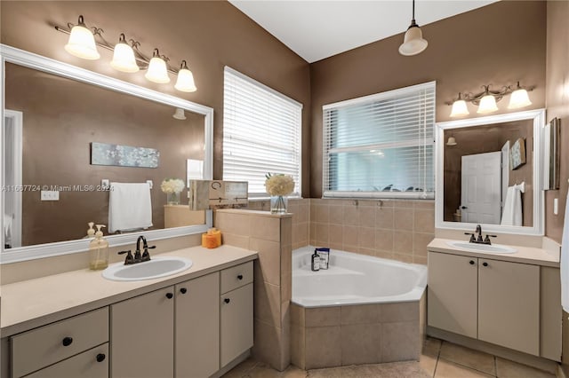 bathroom featuring vanity, tile patterned floors, and a relaxing tiled tub