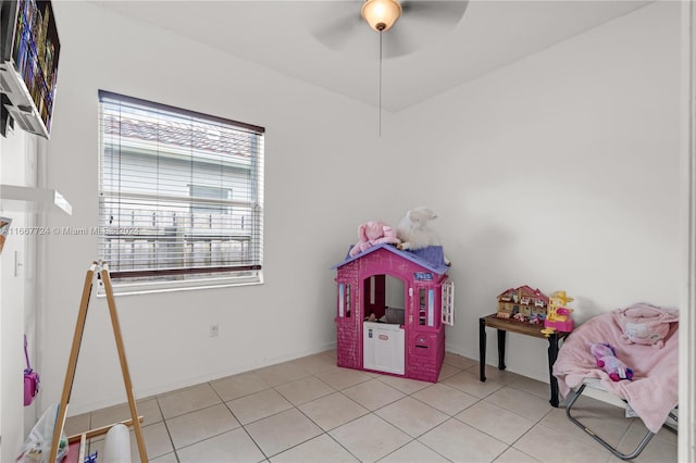 playroom with ceiling fan, light tile patterned floors, and a healthy amount of sunlight