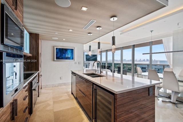 kitchen with pendant lighting, wine cooler, appliances with stainless steel finishes, and sink