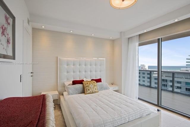 bedroom featuring access to outside, a water view, and light tile patterned flooring