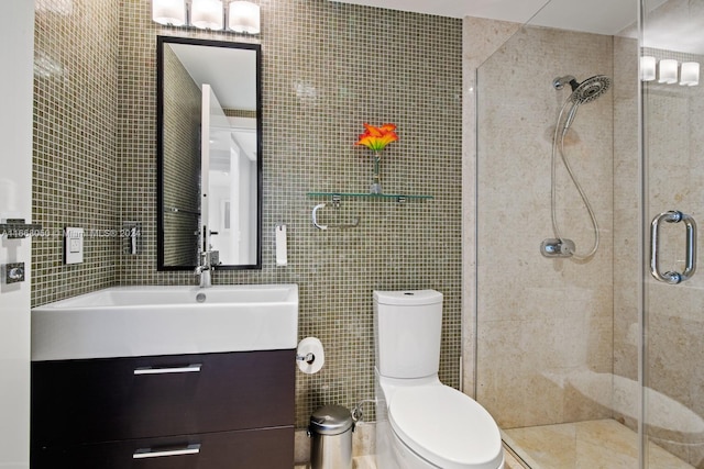 bathroom with tile walls, walk in shower, vanity, and toilet