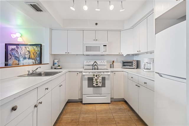 kitchen with light tile patterned floors, white cabinets, sink, and white appliances