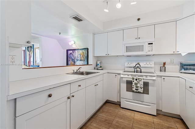 kitchen featuring white cabinets, kitchen peninsula, sink, and white appliances