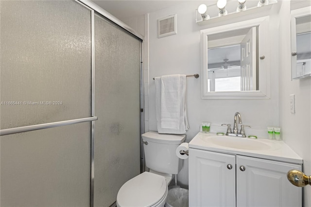 bathroom featuring vanity, toilet, and an enclosed shower