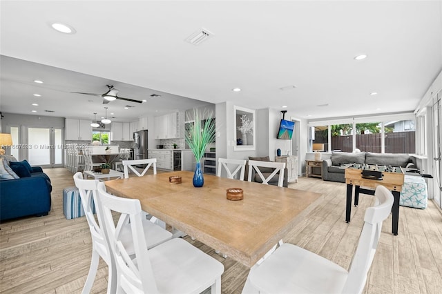 dining space with light wood-type flooring and ceiling fan