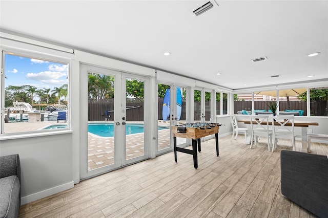 sunroom / solarium featuring french doors