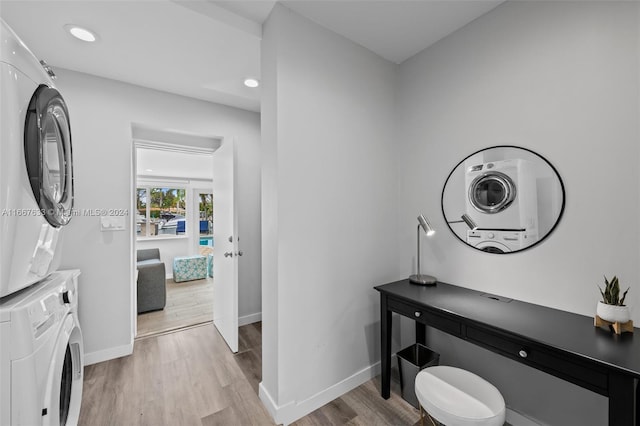 bathroom featuring stacked washer / dryer and hardwood / wood-style flooring