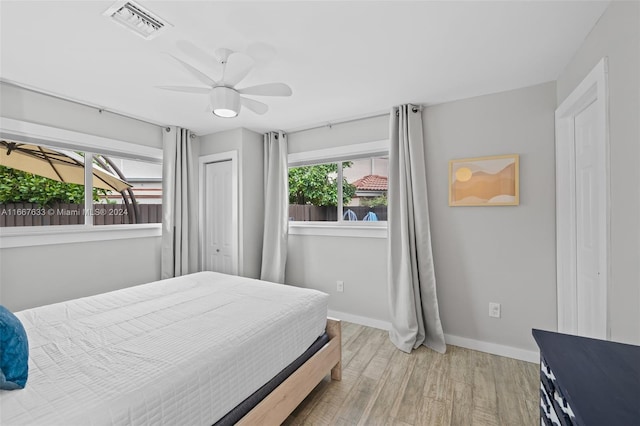 bedroom with ceiling fan, a closet, and light hardwood / wood-style floors