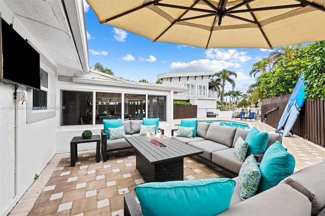 view of patio with a sunroom, a fenced in pool, and an outdoor living space with a fire pit