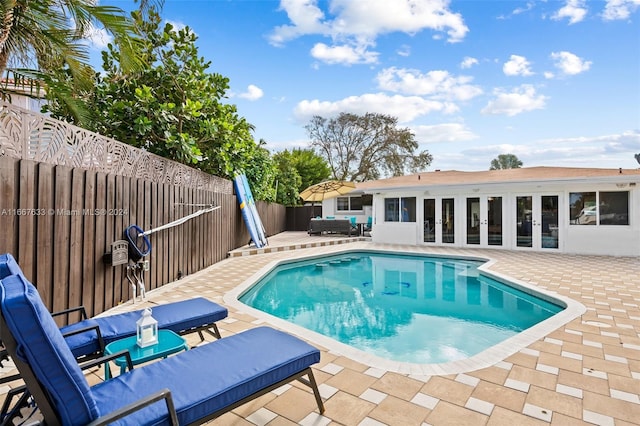 view of pool with french doors and a patio area