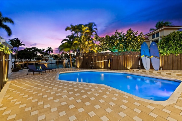 pool at dusk featuring a patio