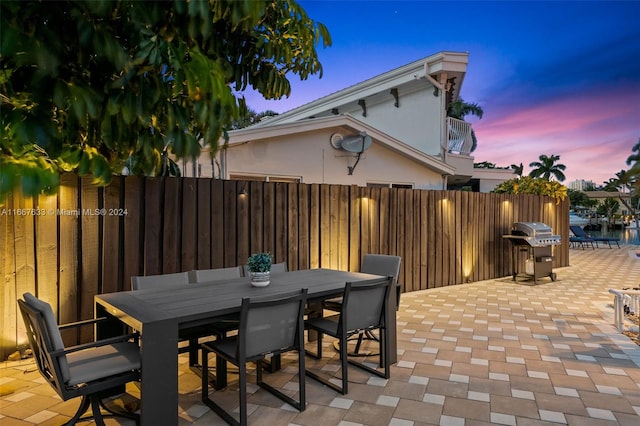 patio terrace at dusk featuring grilling area