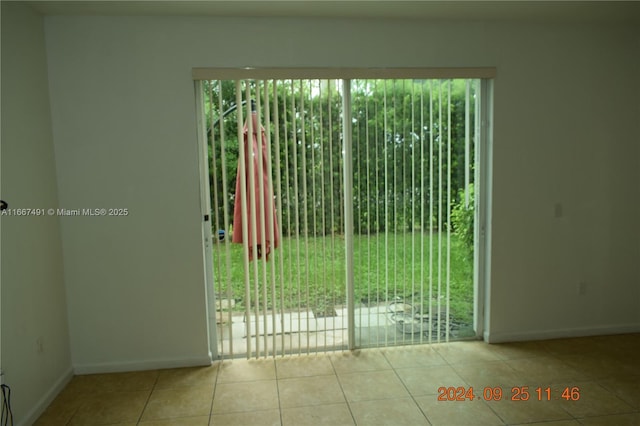 unfurnished room with tile patterned floors, baseboards, and a wealth of natural light