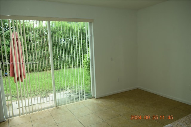 empty room featuring tile patterned floors and baseboards