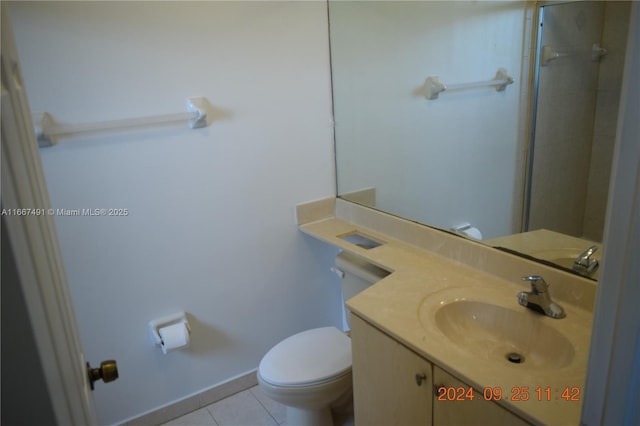 bathroom with vanity, toilet, baseboards, and tile patterned flooring