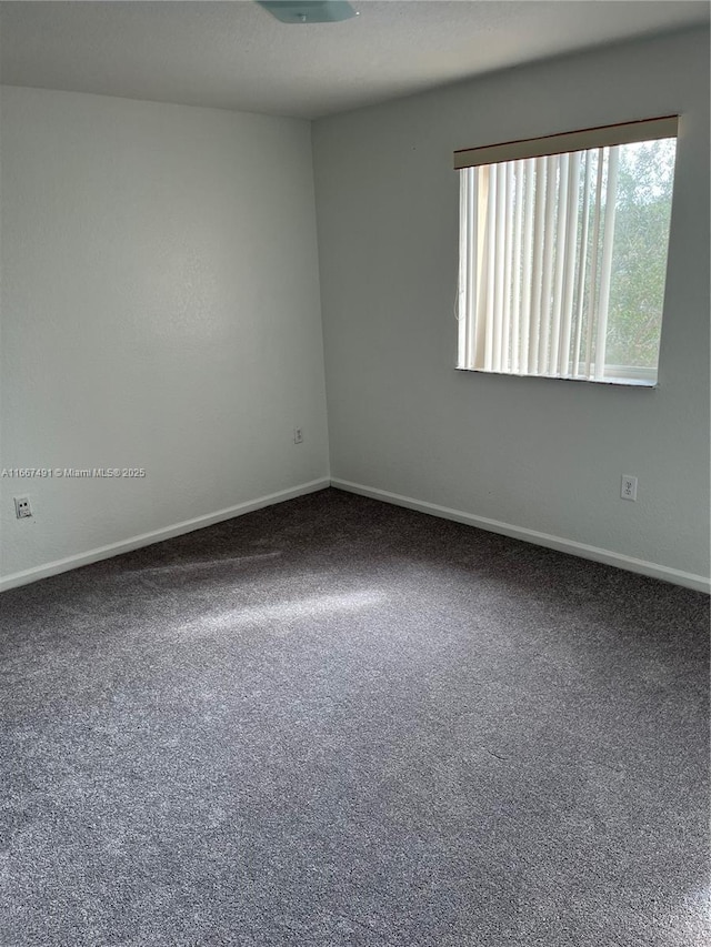 spare room with baseboards and carpet floors