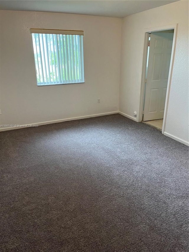 empty room featuring baseboards and carpet