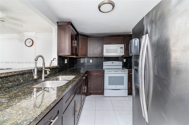 kitchen with backsplash, dark stone counters, sink, white appliances, and ceiling fan