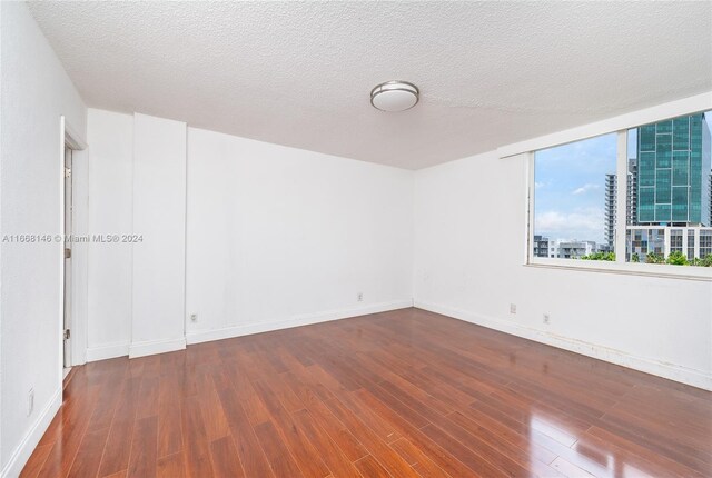 unfurnished room featuring a textured ceiling and hardwood / wood-style floors