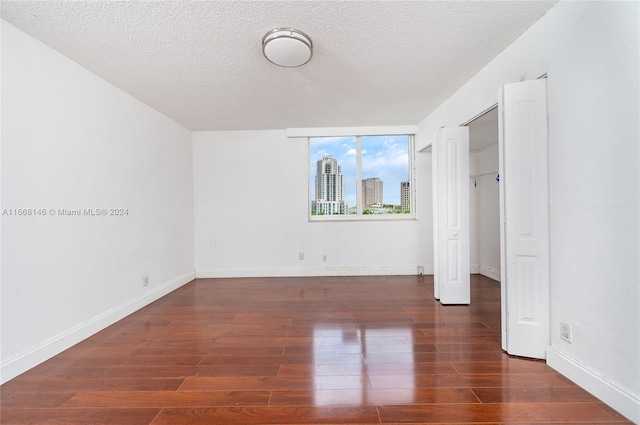 unfurnished bedroom with dark hardwood / wood-style floors and a textured ceiling