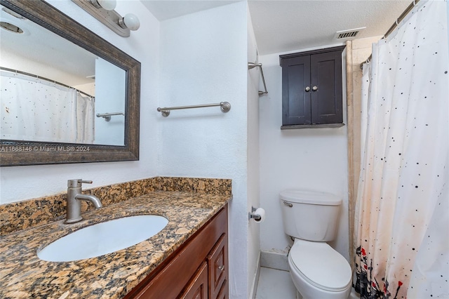 bathroom featuring vanity, curtained shower, a textured ceiling, and toilet