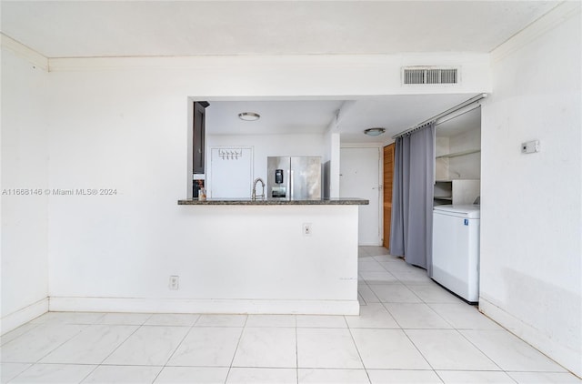 kitchen featuring washer / clothes dryer, stainless steel refrigerator with ice dispenser, kitchen peninsula, sink, and crown molding