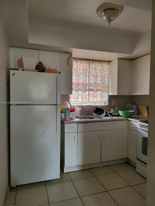1350 NE 119th St Unit 135023, Miami, FL 33161 - kitchen with white appliances, light tile patterned floors, white cabinetry, a raised ceiling, and light countertops