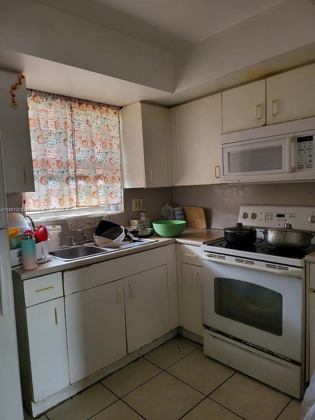 kitchen with white cabinets, white appliances, and light tile patterned floors