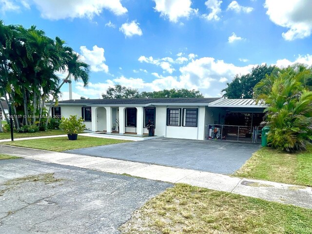 view of front of house with a carport and a front yard