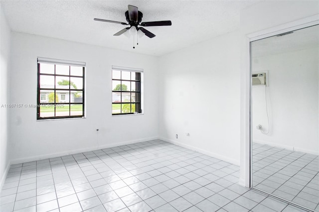 tiled empty room with a textured ceiling and ceiling fan