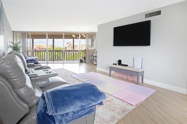 living room featuring an inviting chandelier, hardwood / wood-style floors, and a healthy amount of sunlight