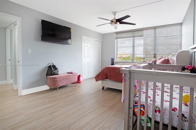 bedroom featuring a closet, light hardwood / wood-style floors, and ceiling fan