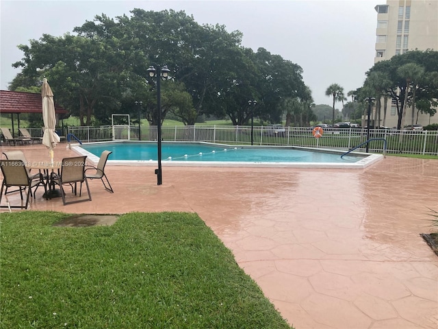 view of pool featuring a yard and a patio