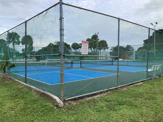 view of tennis court with a lawn