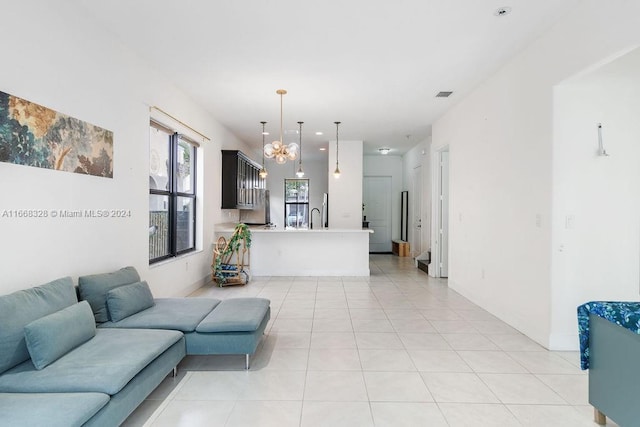 tiled living room featuring sink and a chandelier