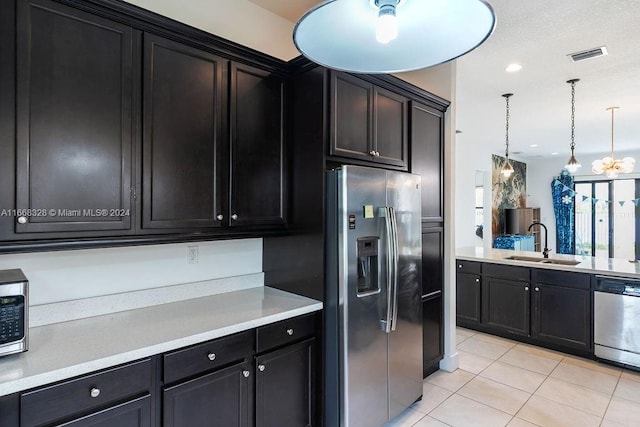 kitchen featuring light tile patterned floors, pendant lighting, appliances with stainless steel finishes, and sink